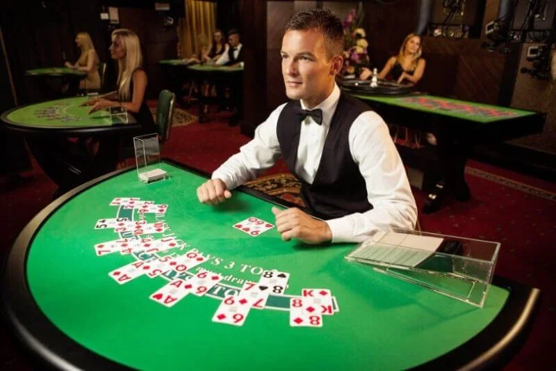 Dealer di ruang kasino live dengan meja permainan